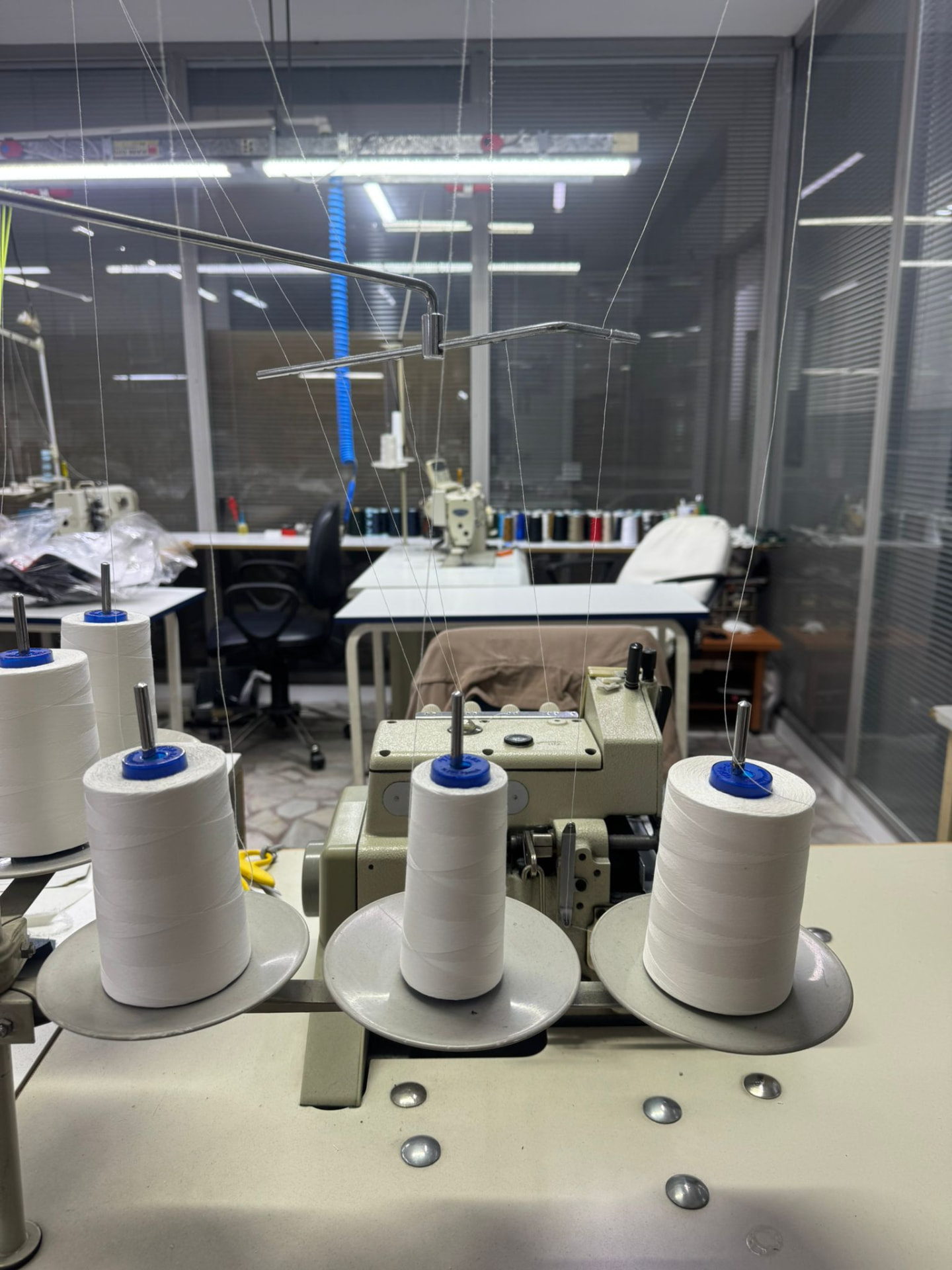 Overlock machine and thread cones on the sewing line